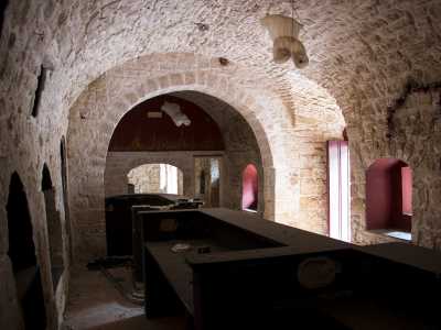 In una stanza adocchiamo ancora intatto il massiccio bancone nero di un bar...